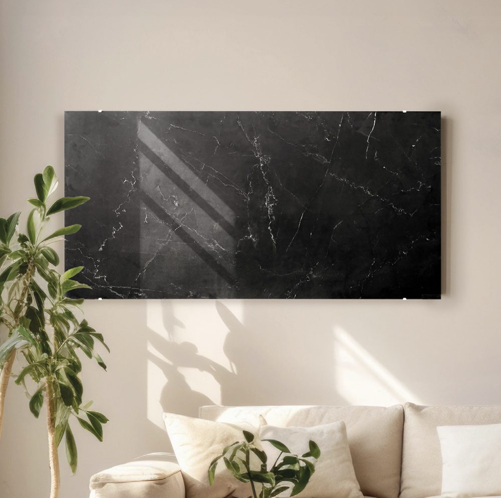 Black marble-effect ceramic infrared panel above a sofa